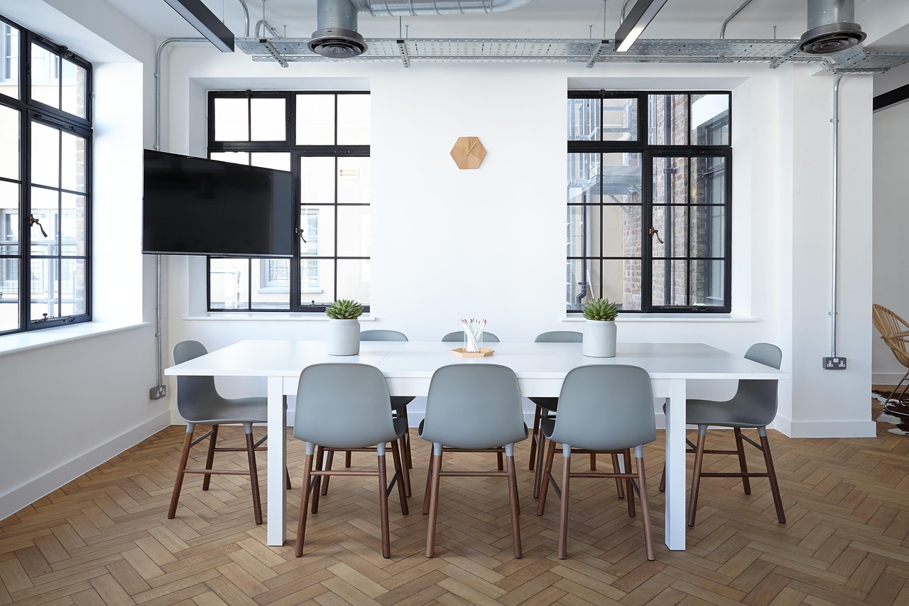 light filled room with windows, a conference table, and chairs